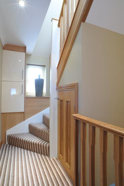 small oak cupboard under loft conversion stairs is ideal use of space  